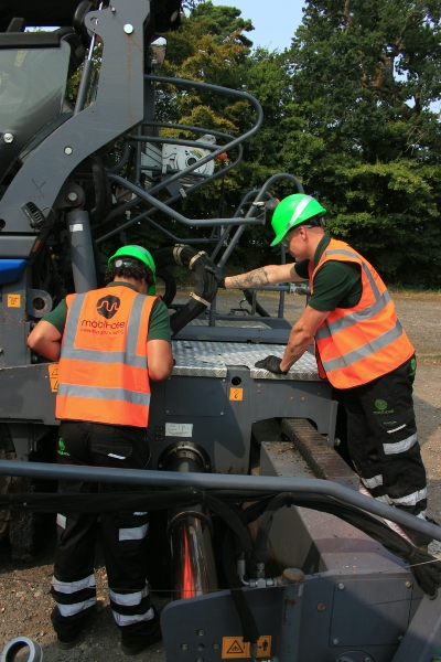 2 engineers inspecting a construction machine on a mobile hose and hydraulic emergency call out.