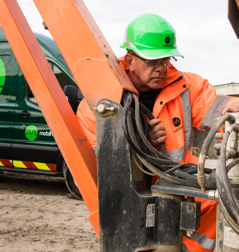 Engineer inspecting hydraulic hoses